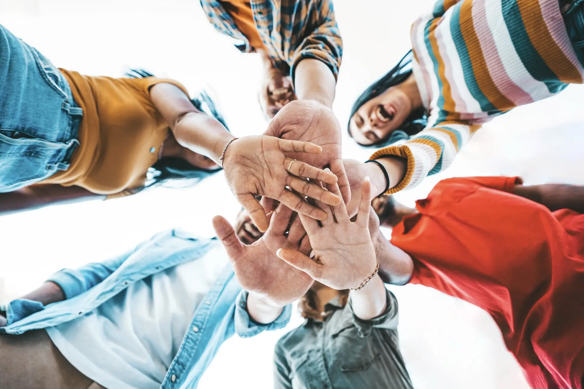 Team in a circle with hands joined, symbolizing teamwork and collaboration